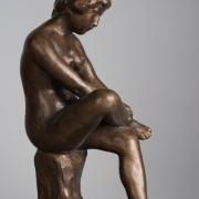 Сидящая женщина, положившая правую ногу на левую